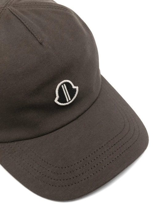 Close up of brown cap, showing the logo detail and the texture of cotton fabric