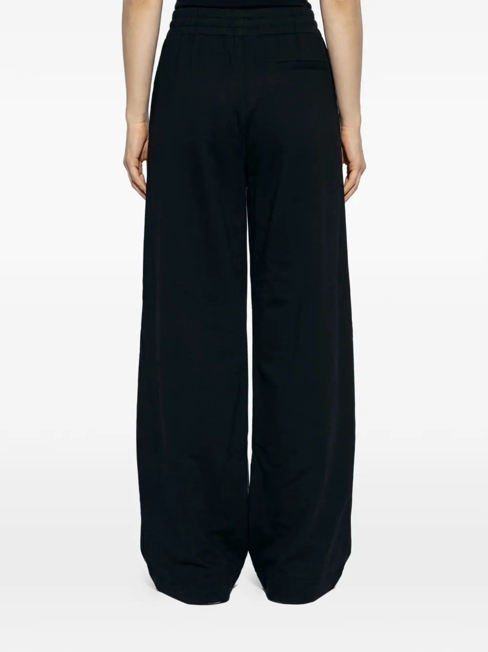 Black pants worn by a person, showing the pants fit