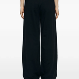 Black pants worn by a person, showing the pants fit