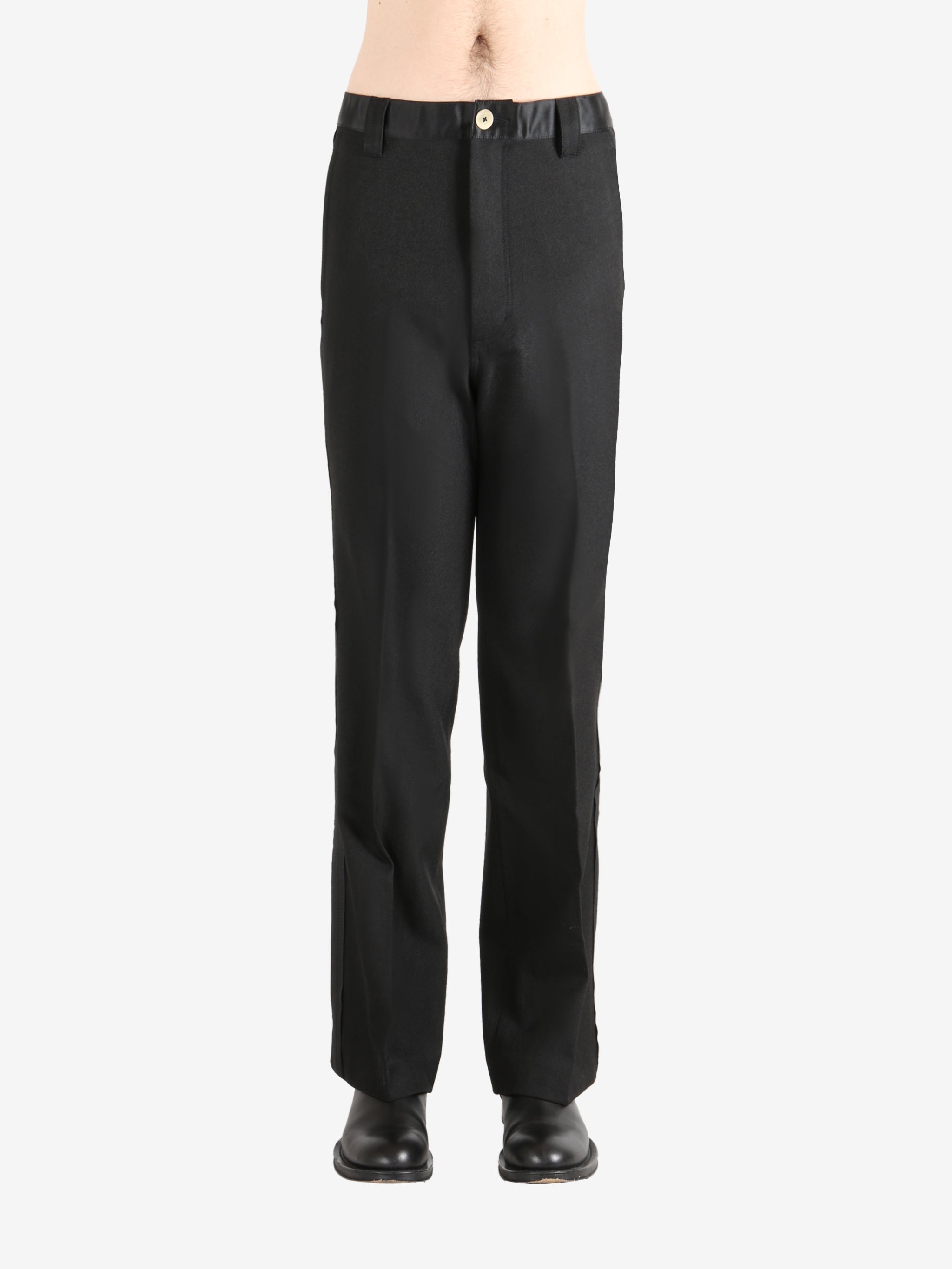 Black trouser worn by a person, showing the trouser's fit