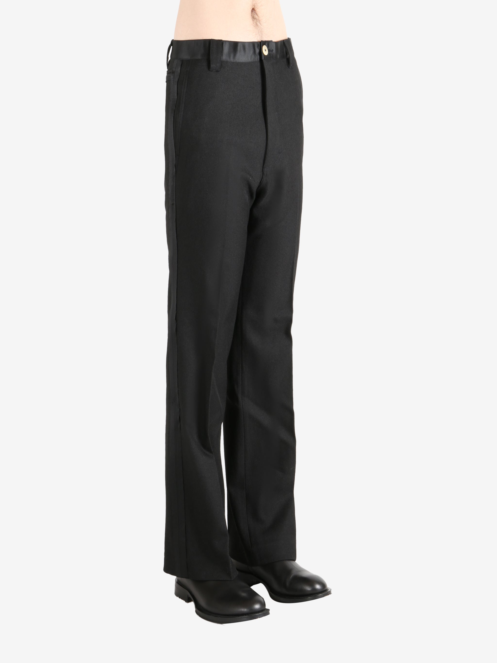 Black trouser worn by a person, showing the trouser's fit