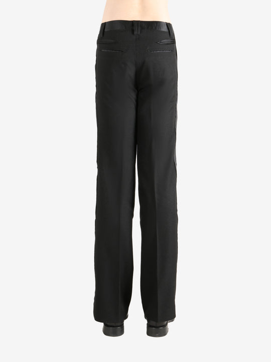 Black trouser worn by a person, showing the trouser's fit