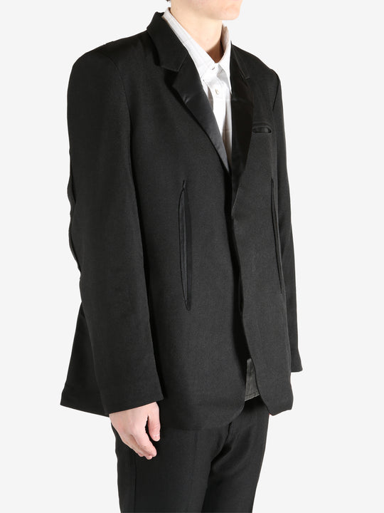 Black blazer worn by a person, showing the blazer's fit