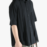 Black shirt worn by a person, showing the shirt's fit