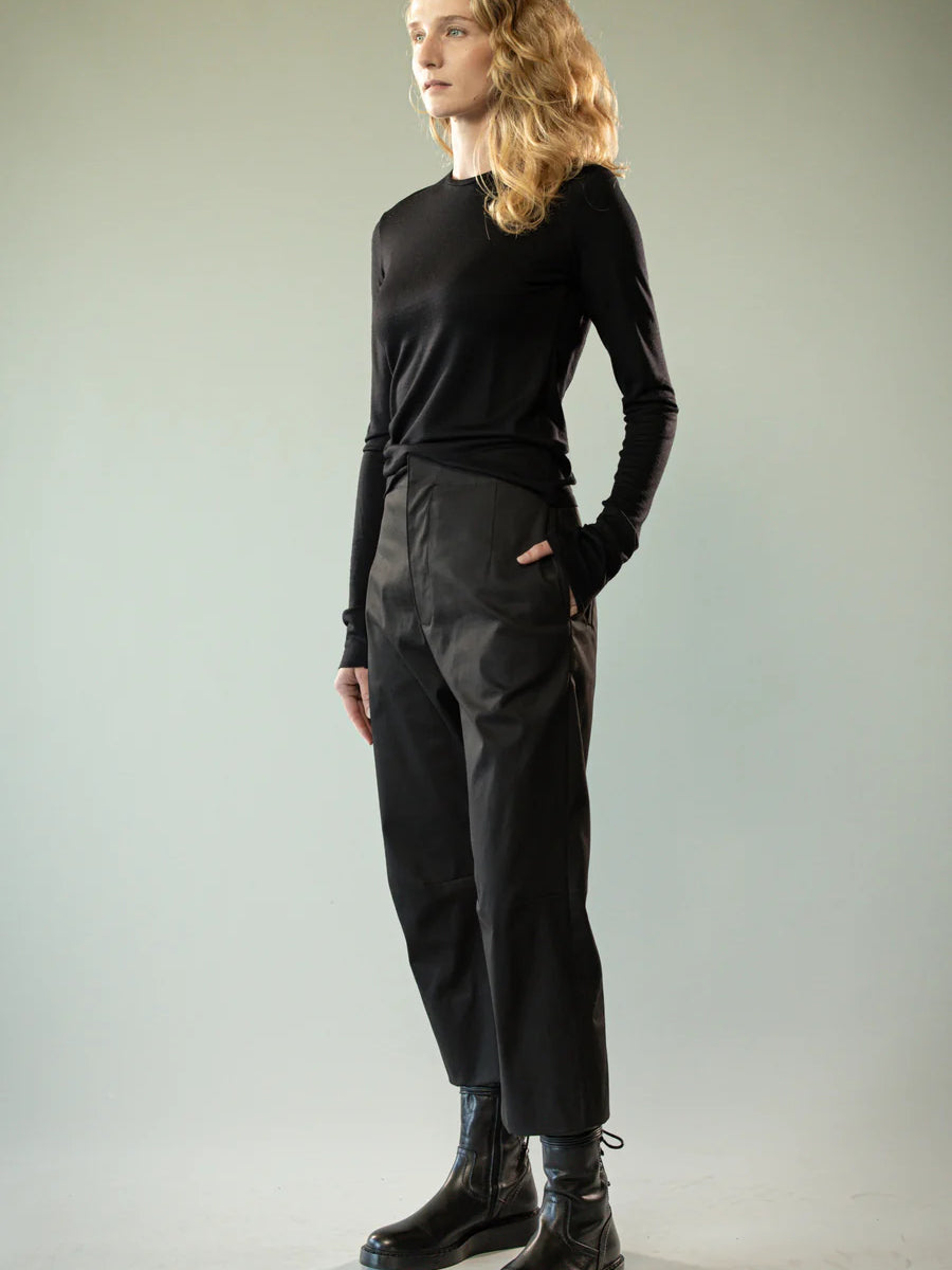 Black knitwear worn by a person, showing the knitwear's fit