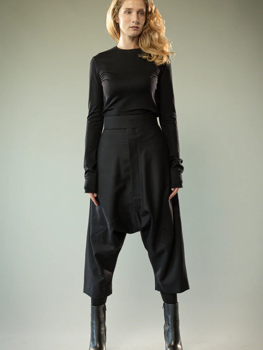 Black pants worn by a person, showing the pants' fit