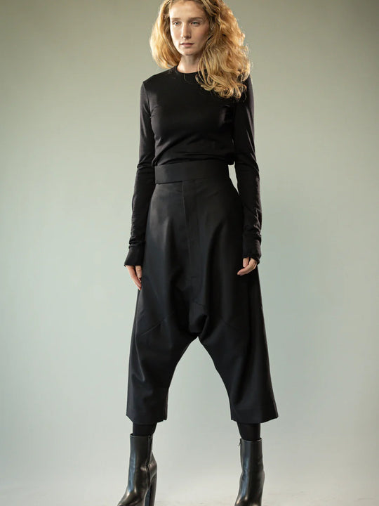 Black pants worn by a person, showing the pants' fit