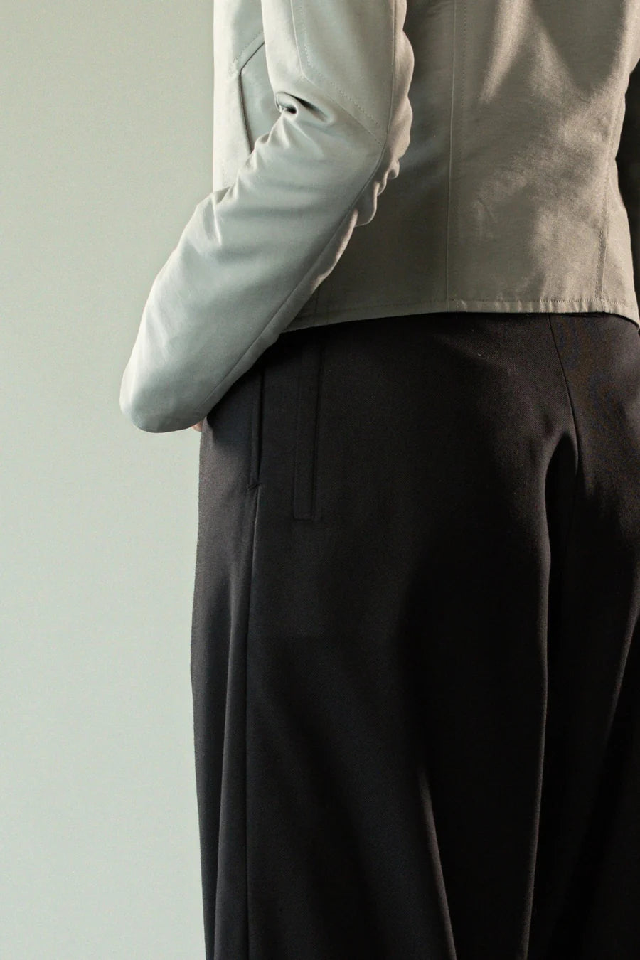 Close up of black pants, showing texture of the wool twill fabric