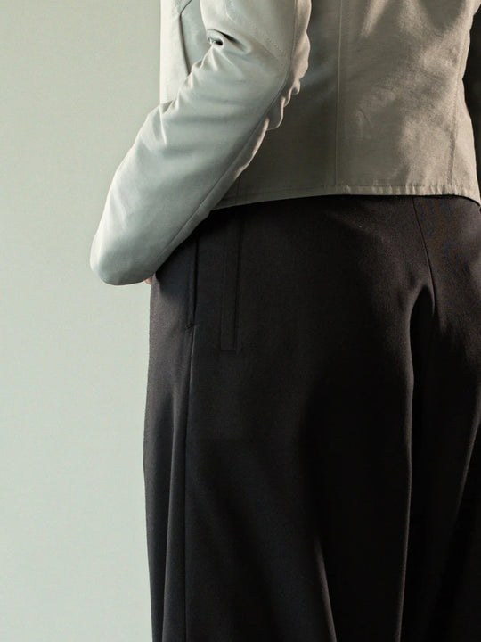 Close up of black pants, showing texture of the wool twill fabric