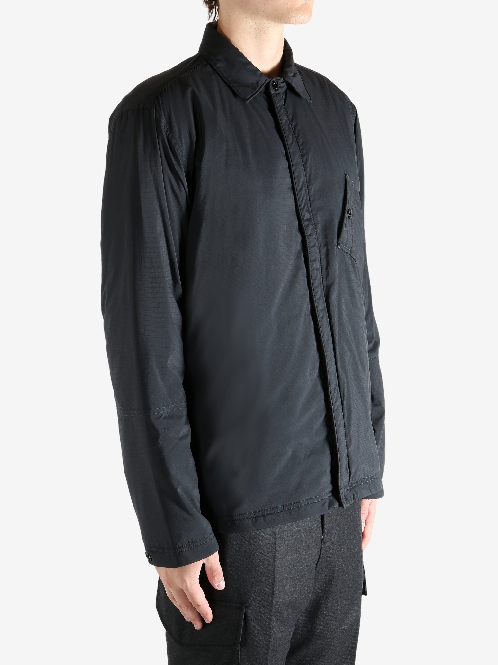 Black striped shirts worn by a person, showing the shirt's fit