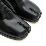 Close up of the black shoes, showing texture of the leather fabric
