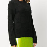 Black knitwear worn by a person, showing the knitwear fit