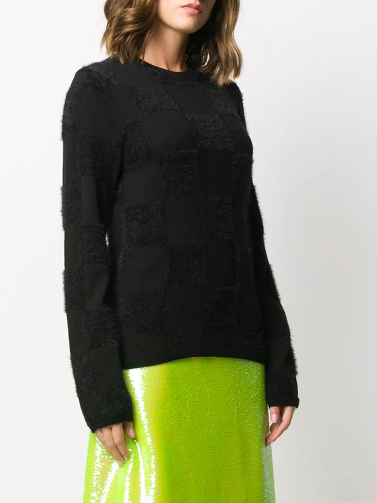 Black knitwear worn by a person, showing the knitwear fit