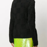 Black knitwear worn by a person, showing the knitwear fit