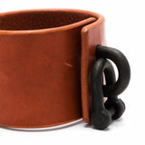 Close up of red bracelet, showing texture of the leather fabric