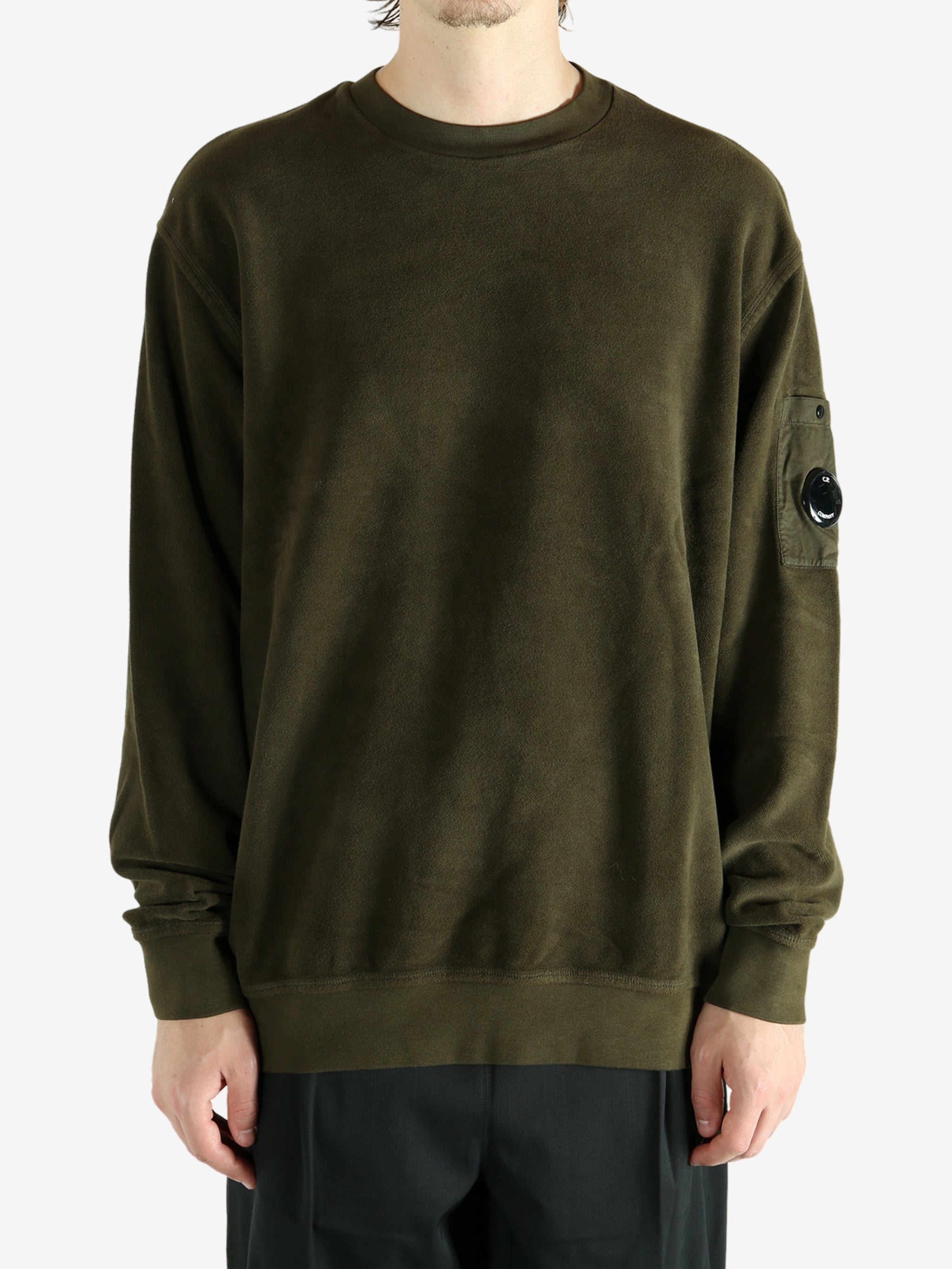 Green sweatshirt worn by a person, showing the sweatshirt's fit