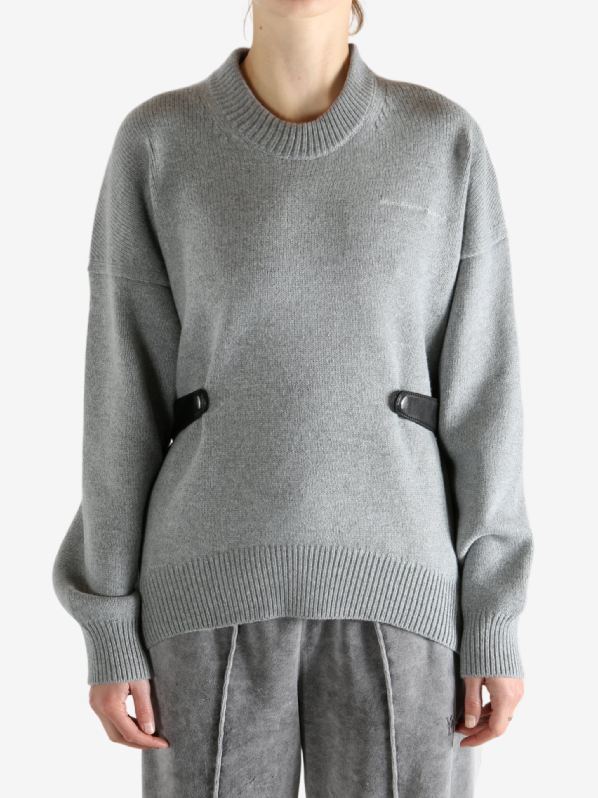 Gray sweater worn by a person, showing the sweater's fit