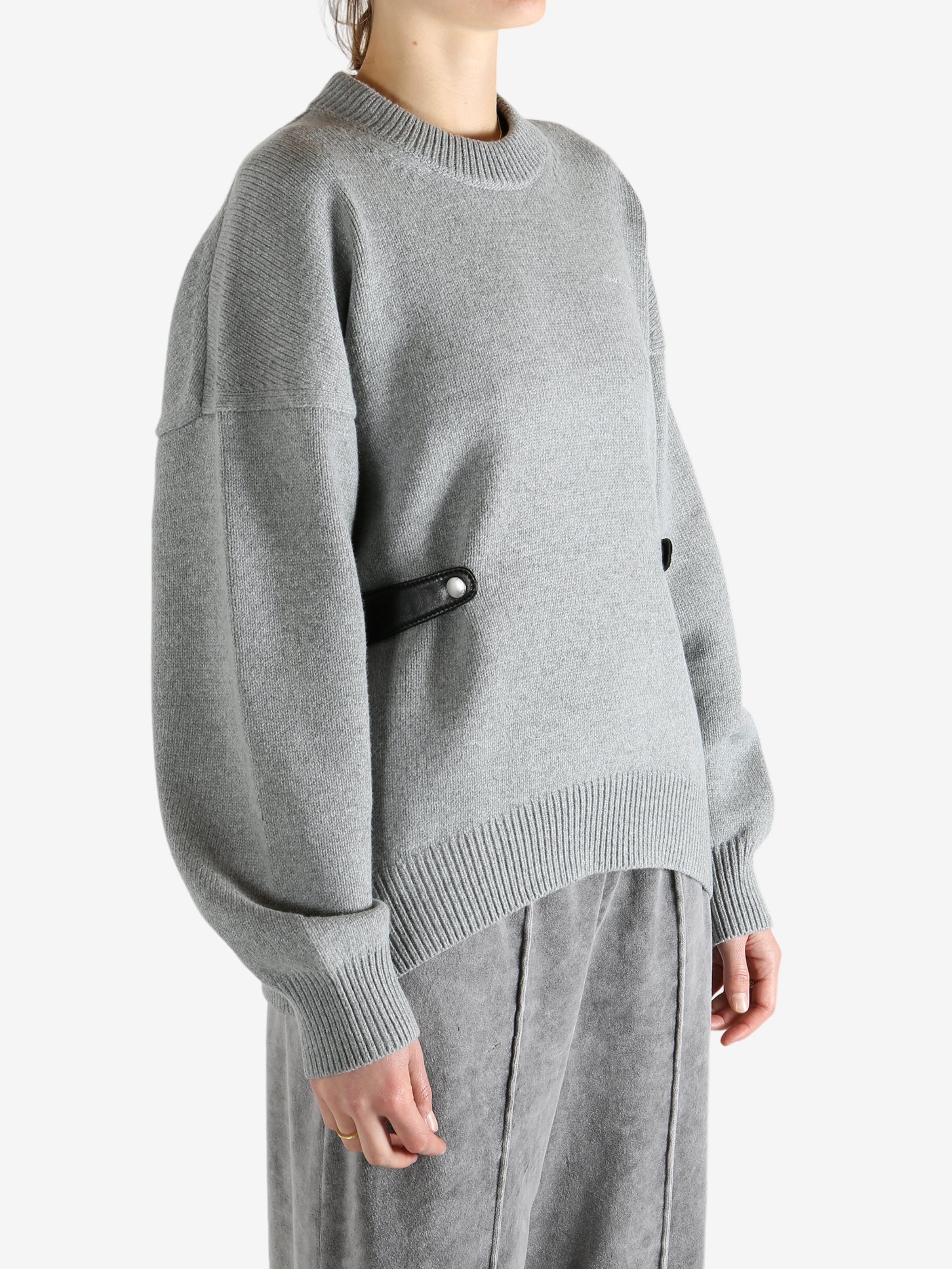 Gray sweater worn by a person, showing the sweater's fit