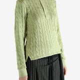 Green knitwear worn by a person, showing the knitwear's fit