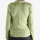 Green knitwear worn by a person, showing the knitwear's fit