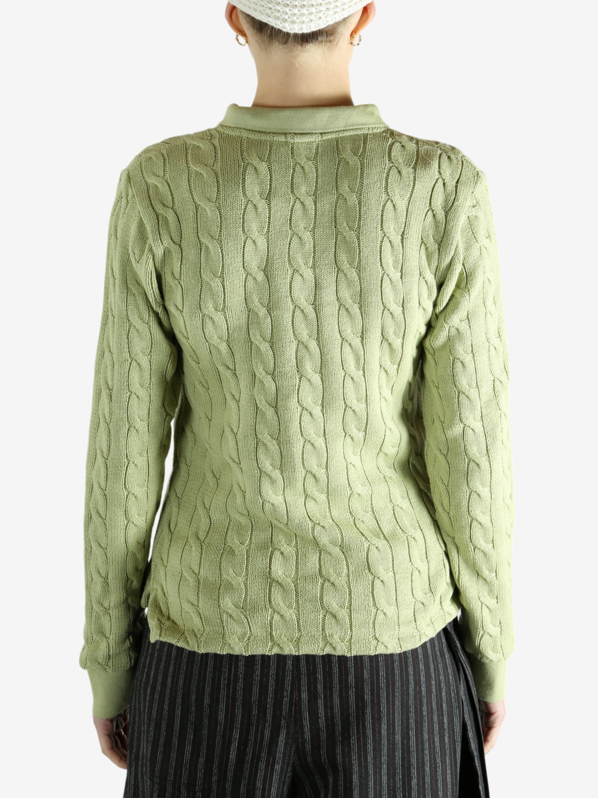 Green knitwear worn by a person, showing the knitwear's fit