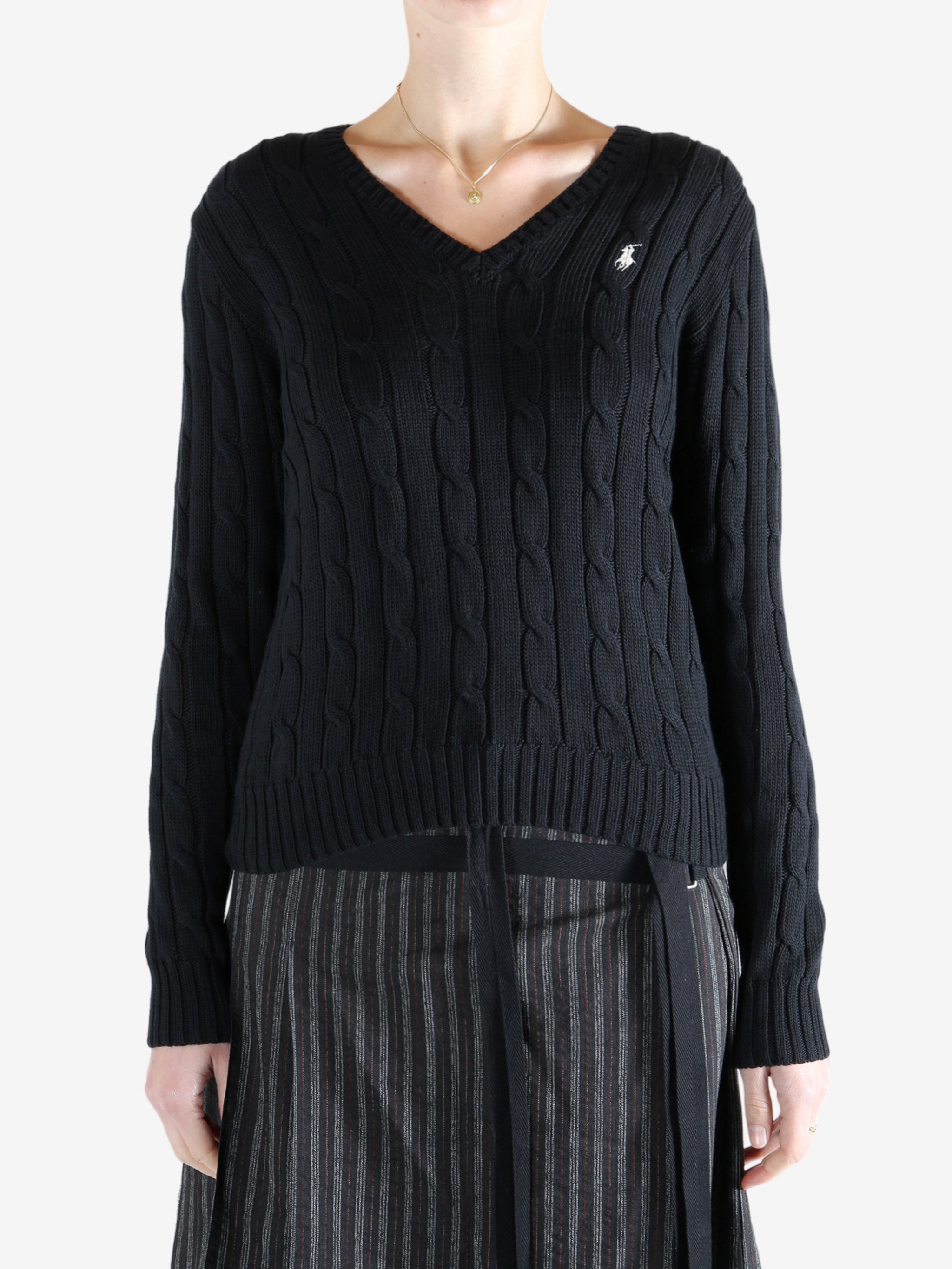 Black knitwear worn by a person, showing the knitwear fit