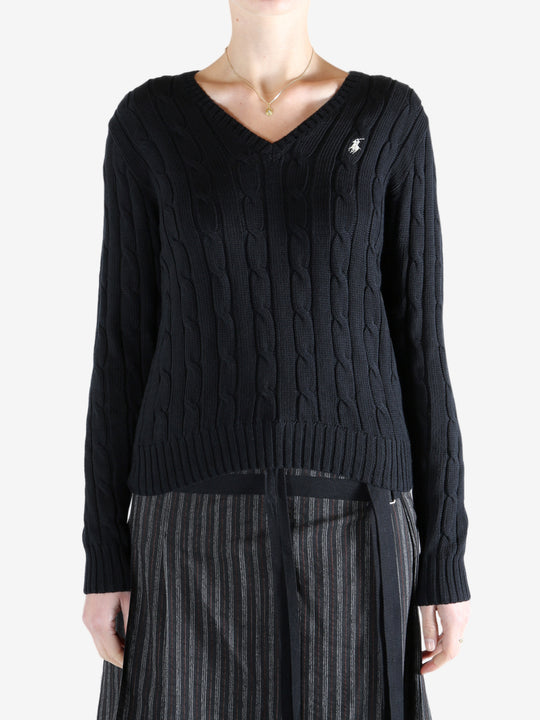 Black knitwear worn by a person, showing the knitwear fit