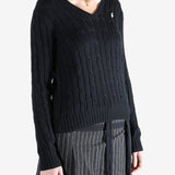 Black knitwear worn by a person, showing the knitwear fit