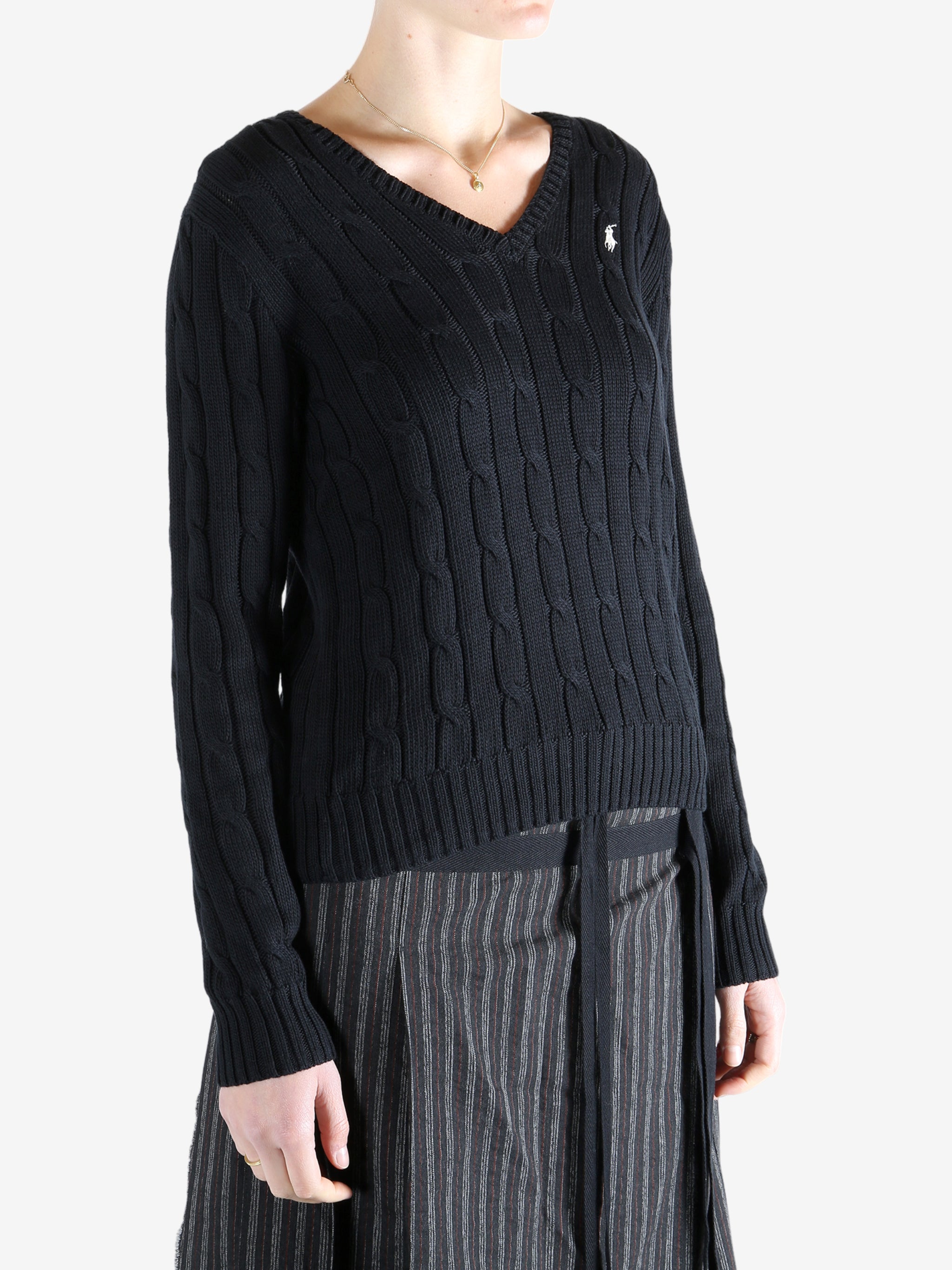 Black knitwear worn by a person, showing the knitwear fit