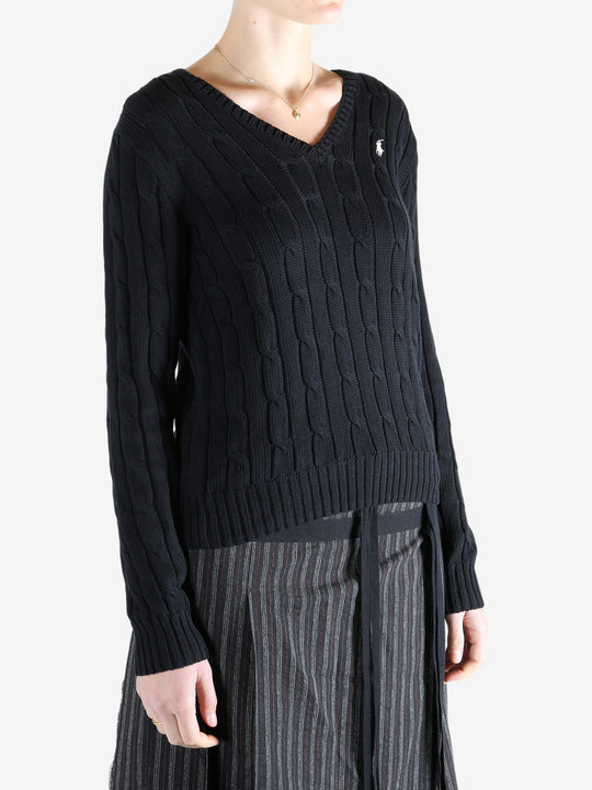Black knitwear worn by a person, showing the knitwear fit