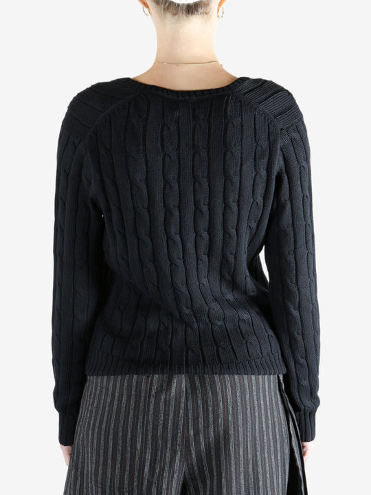 Black knitwear worn by a person, showing the knitwear fit