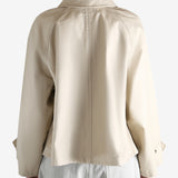 A tan jacket worn by a person, showing the jacket's fit