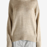 A tan sweater worn by a person, showing the sweater's fit