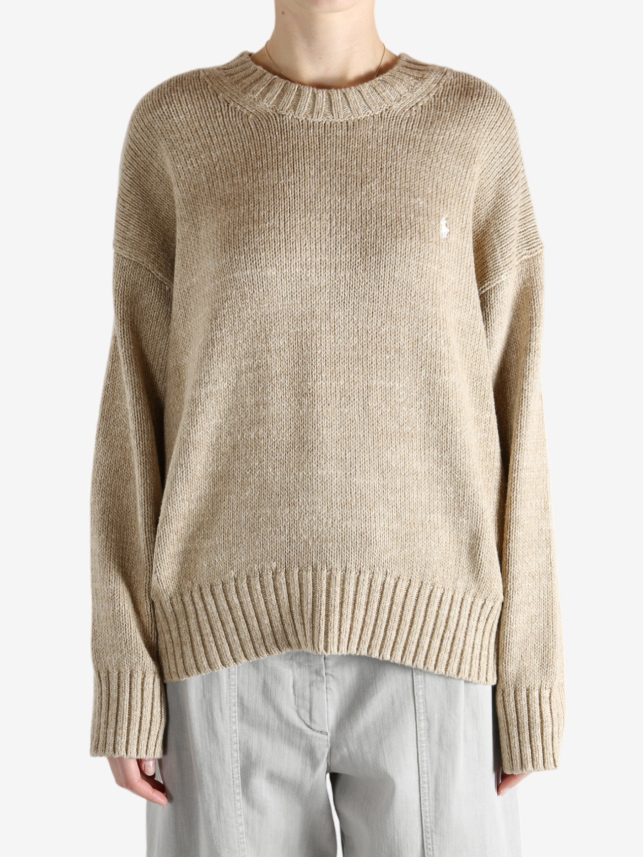 A tan sweater worn by a person, showing the sweater's fit