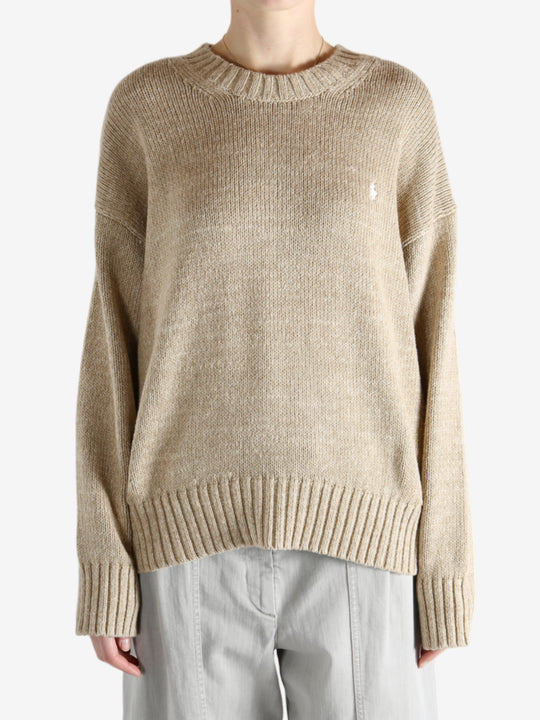 A tan sweater worn by a person, showing the sweater's fit