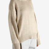 A tan sweater worn by a person, showing the sweater's fit