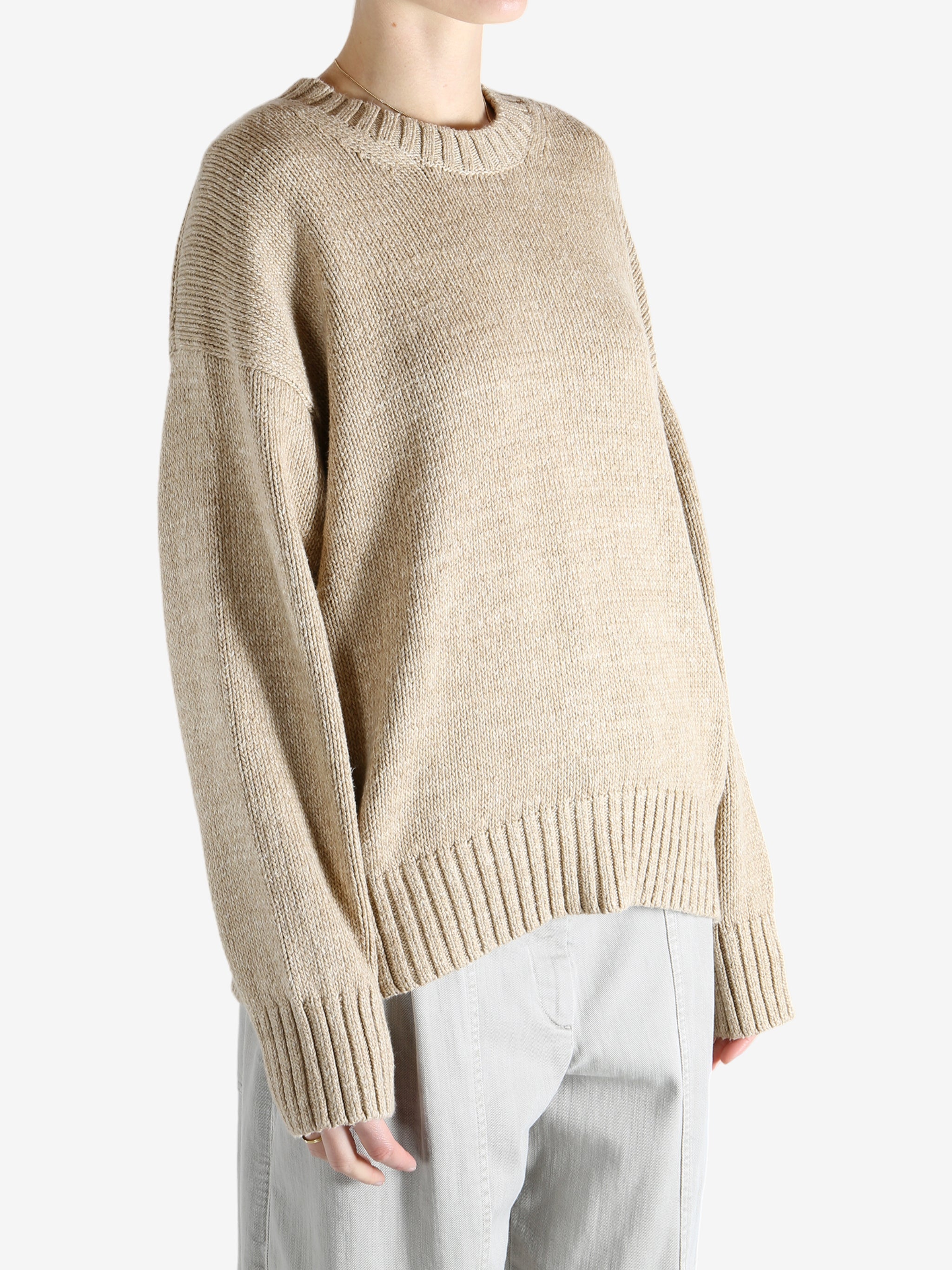 A tan sweater worn by a person, showing the sweater's fit