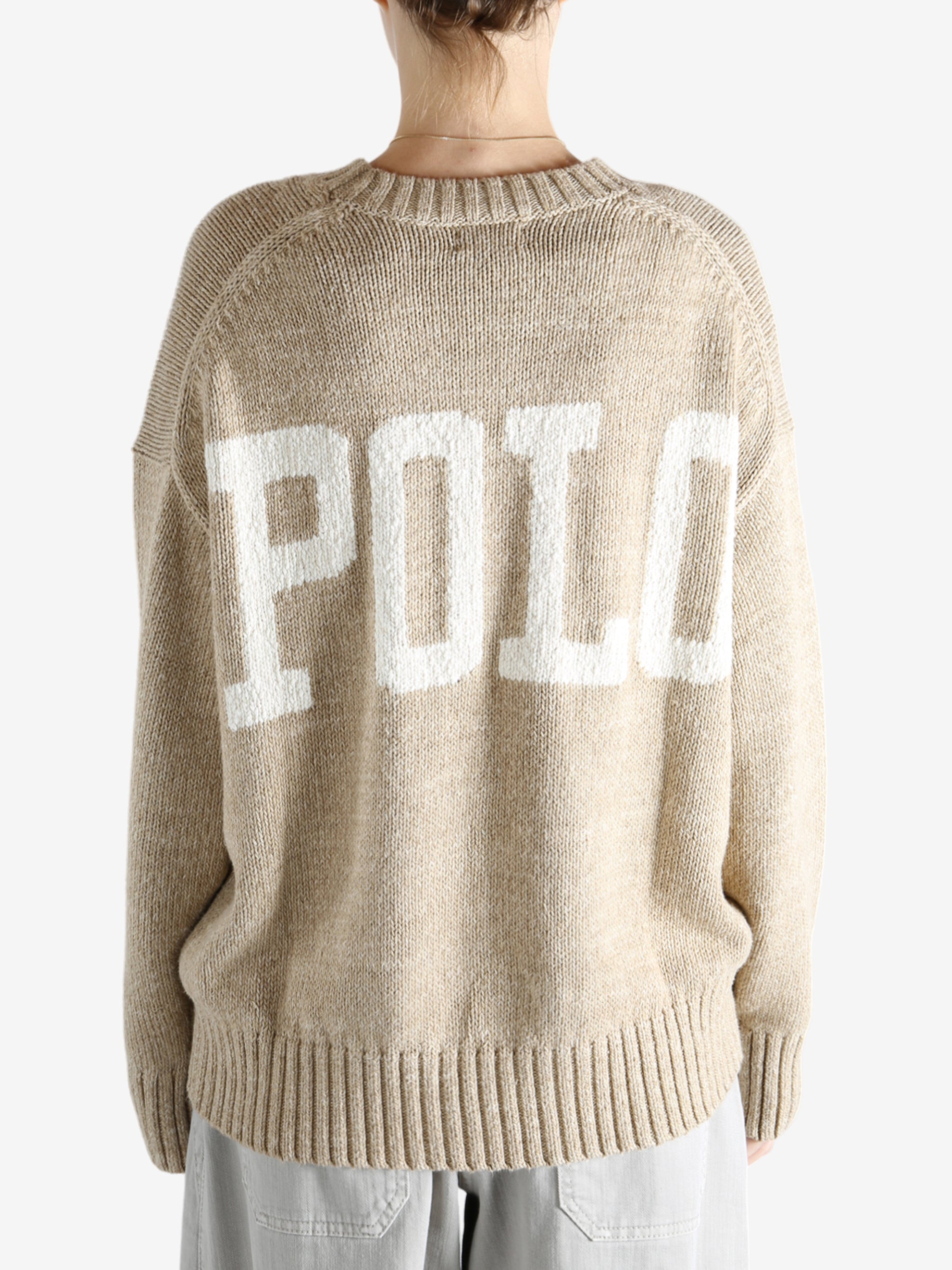 A tan sweater worn by a person, showing the sweater's fit