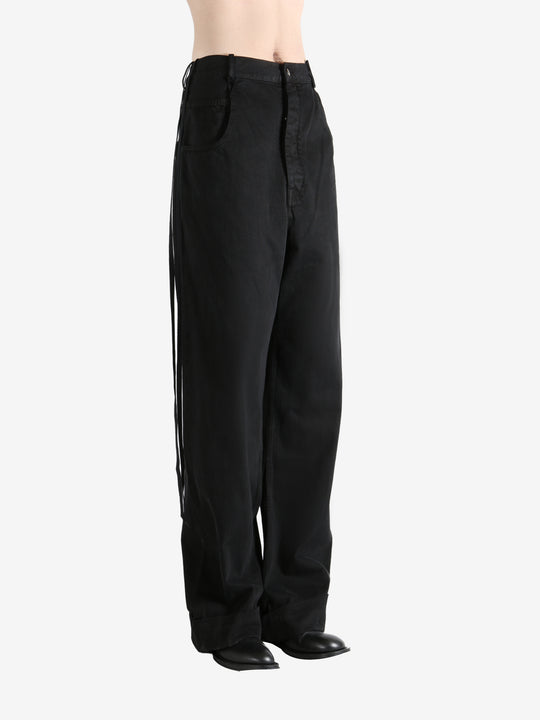 Black trousers worn by a person, showing the trousers fit