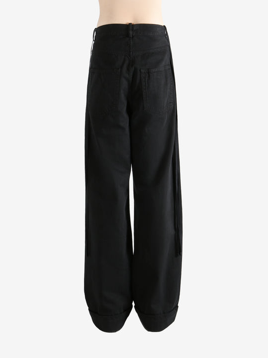 Black trousers worn by a person, showing the trousers fit