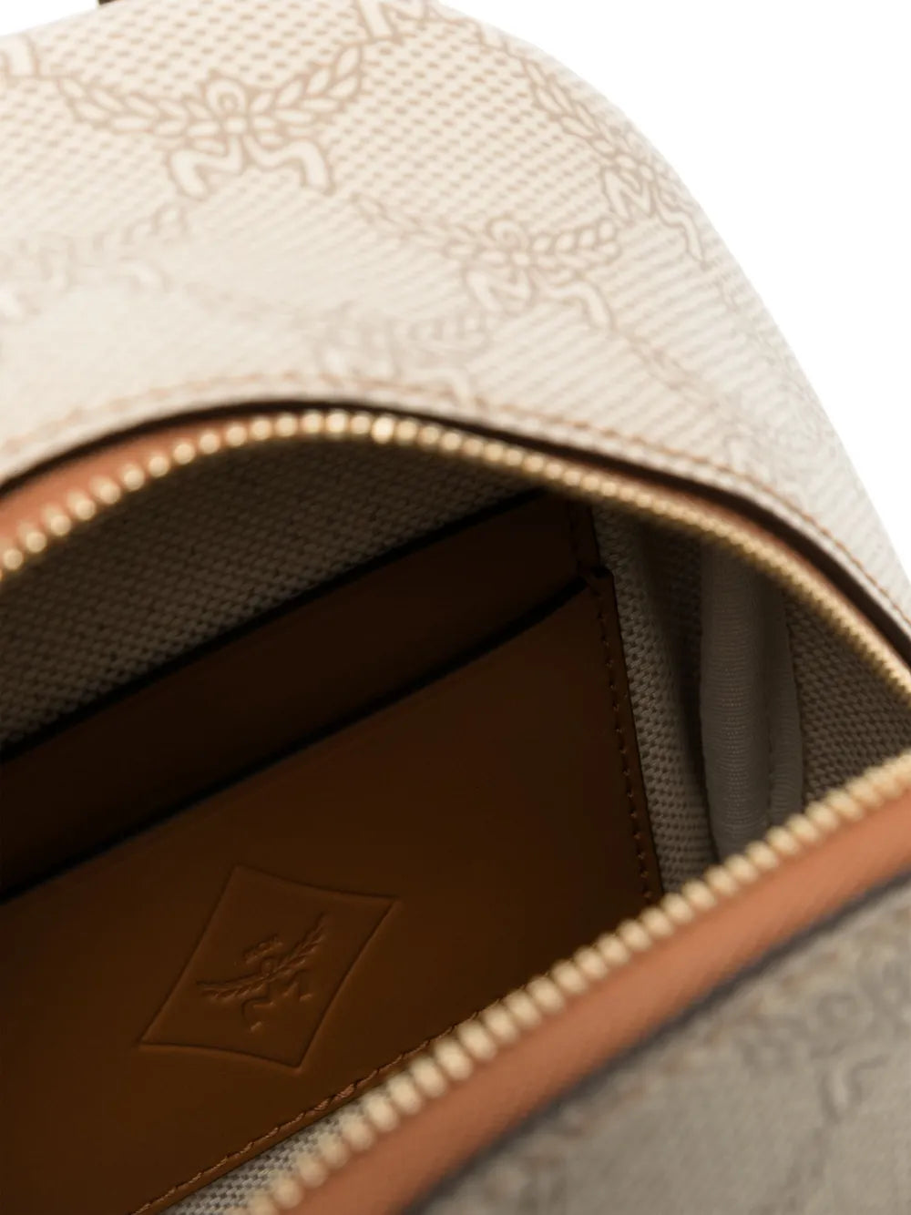 Close up of tan backpack, showing texture of the canvas and leather fabric