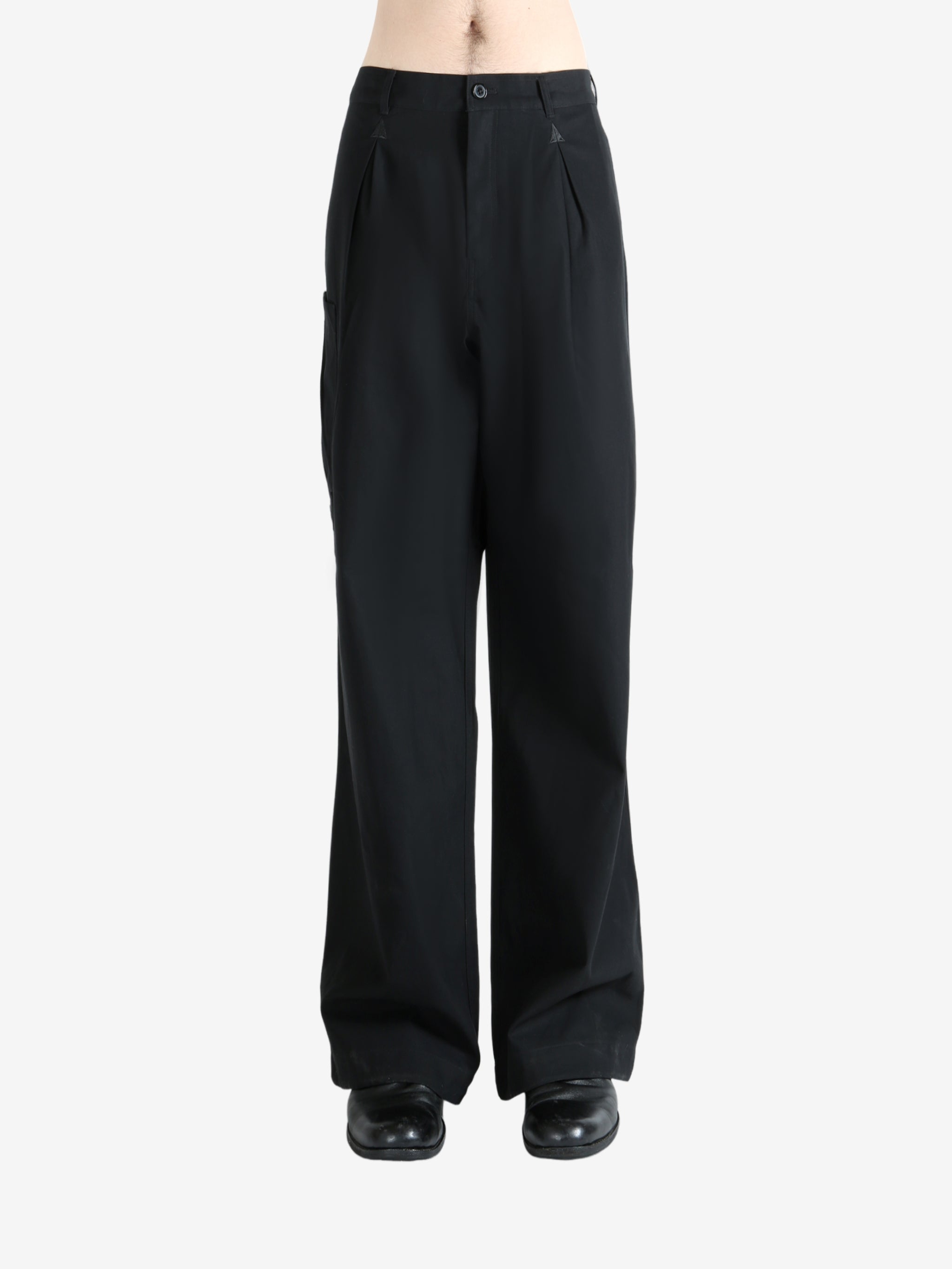 Black pants worn by a person, showing the pants' fit