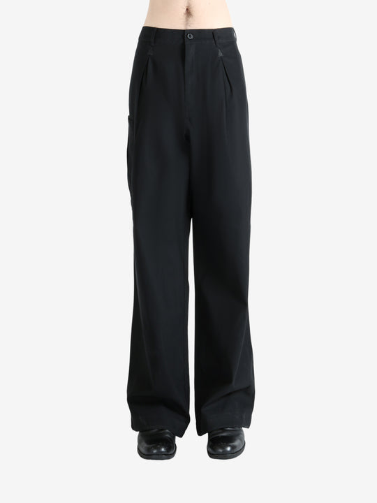 Black pants worn by a person, showing the pants' fit