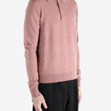 Pink sweater worn by a person, showing the sweater's fit
