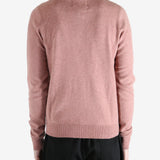 Pink sweater worn by a person, showing the sweater's fit