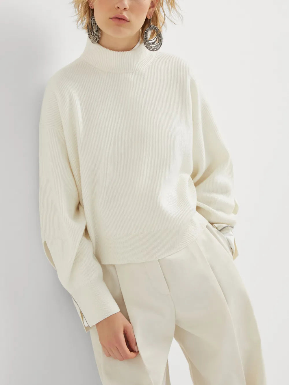 White knitwears worn by a person, showing the knitwears fit