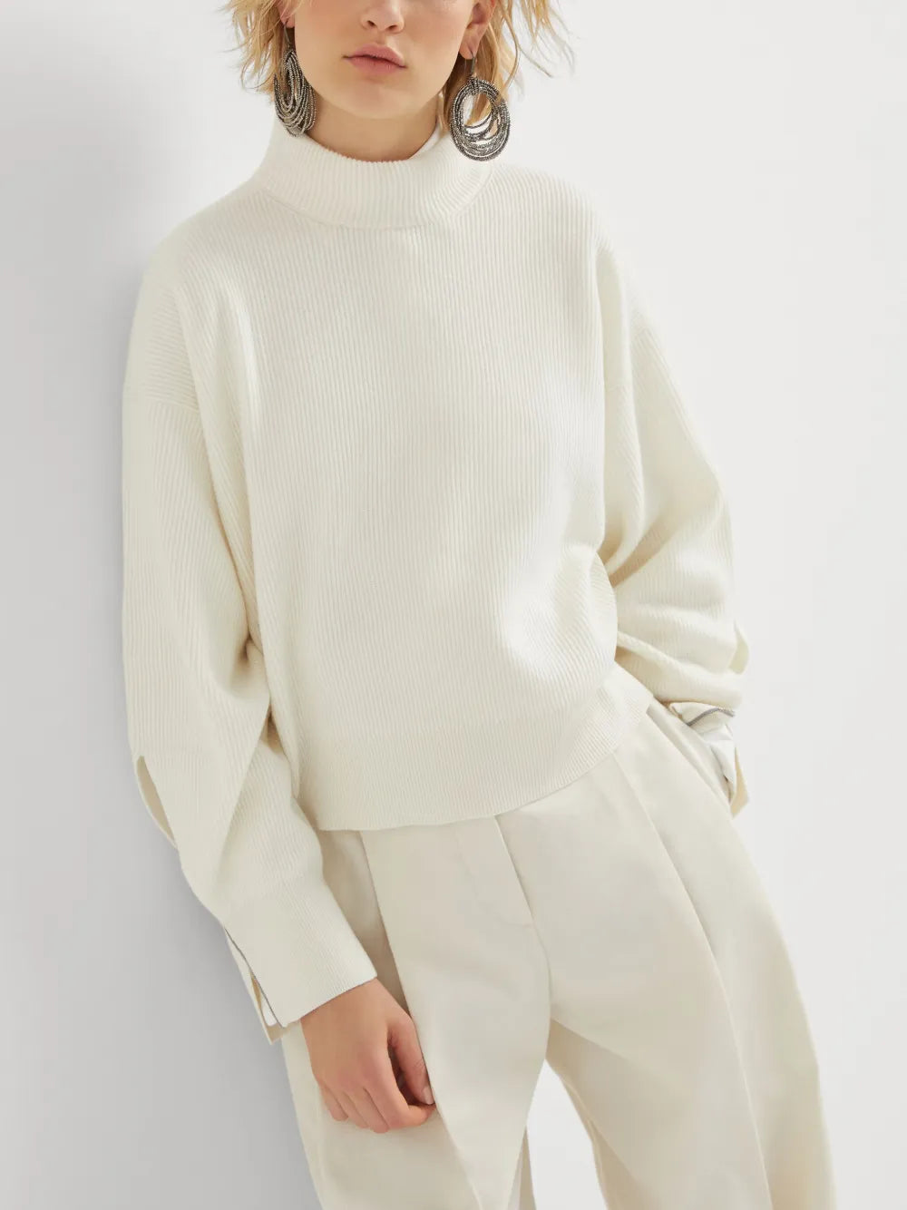 White knitwears worn by a person, showing the knitwears fit