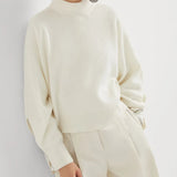 White knitwears worn by a person, showing the knitwears fit