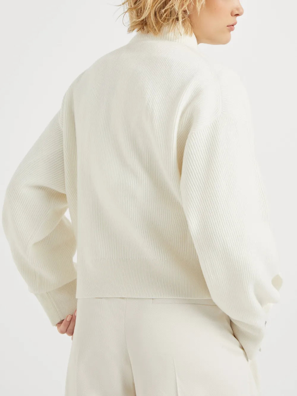 White knitwears worn by a person, showing the knitwears fit