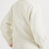 White knitwears worn by a person, showing the knitwears fit